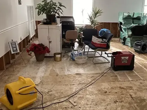 Air movers on an exposed living room floor after water damage