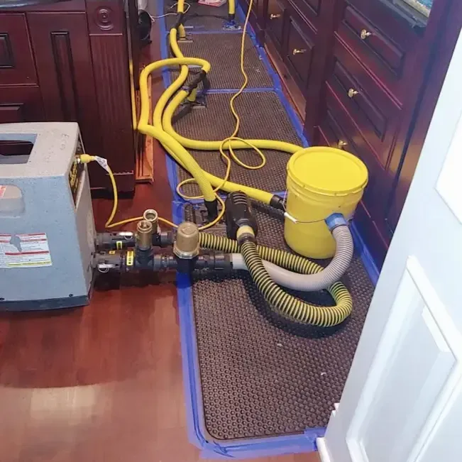 Drying hoses and floor equipment beside kitchen cabinets